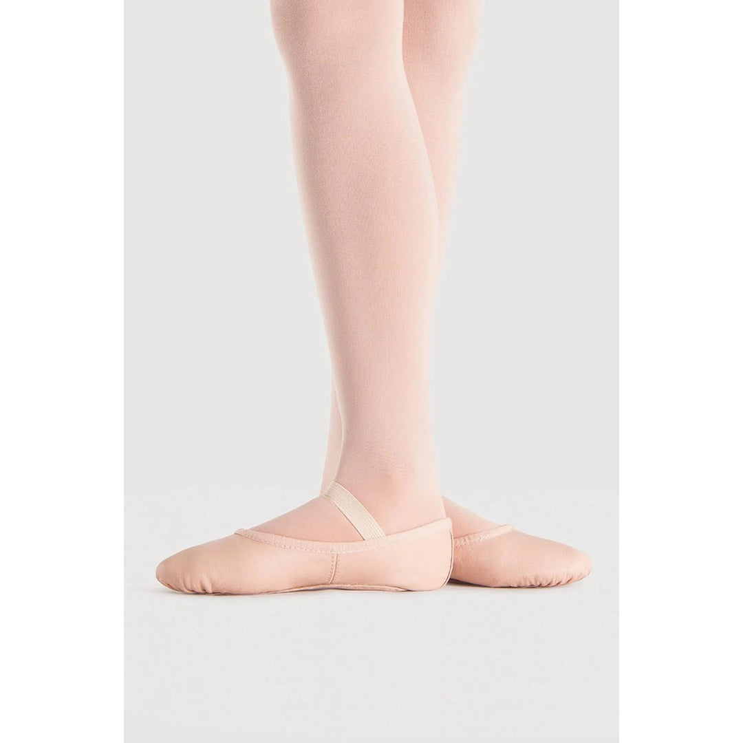 A pair of light pink ballet slippers worn on a dancer&