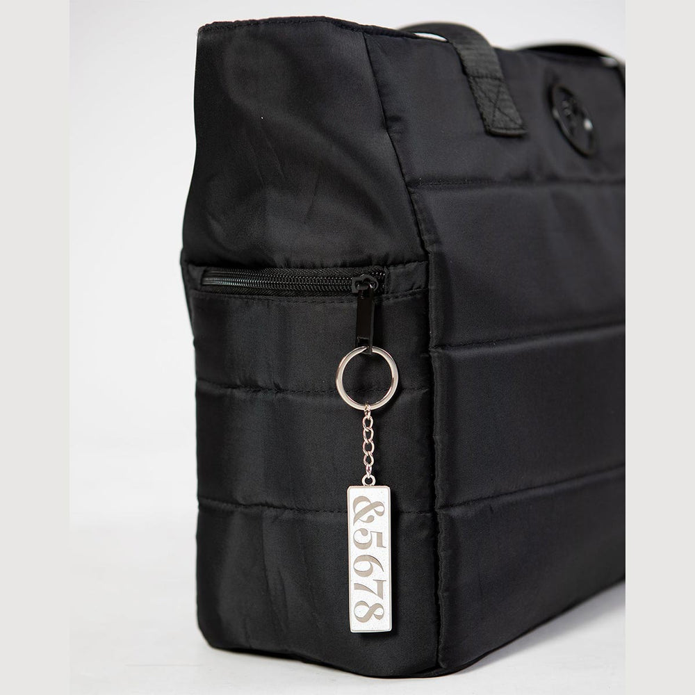 Energetiks 5678 dance key ring in silver hanging from a dance bag