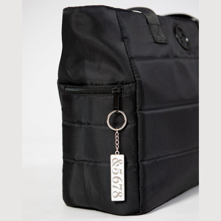 Energetiks 5678 dance key ring in silver hanging from a dance bag